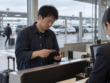旅客在机场租车柜台准备实体银行卡与钱包的真人摄影风格 AI 示意图